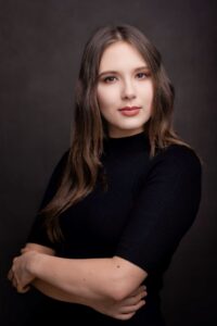 Anna Zborowska w czarnej bluzce z rękami skrzyżowanymi