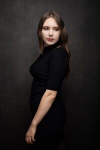 Anna Zborowska w czarnej sukience, bokiem