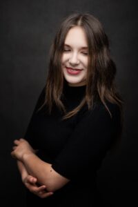 Uśmiechnięta Anna Zborowska w czarnej bluzce
