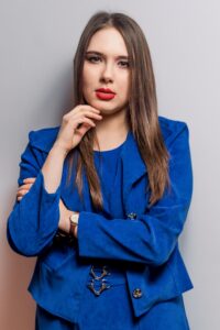 Anna Zborowska w kobaltowym żakiecie, jasne tło
