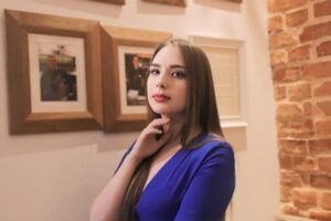 Anna Zborowska przy ceglanej ścianie w kawiarni