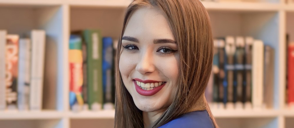 Anna Zborowska przy regale z książkami, fot. Tomasz Krysiak