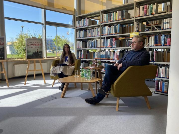 Spotkanie autorskie w bibliotece – rozmowa w fotelach przy regałach