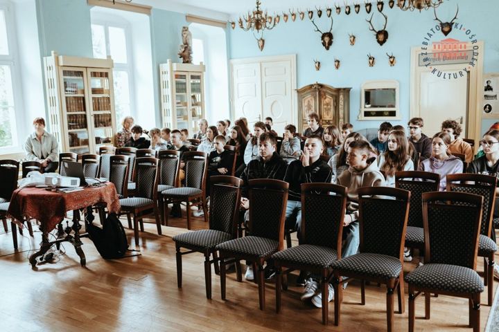 Publiczność w pałacowej sali z żyrandolami