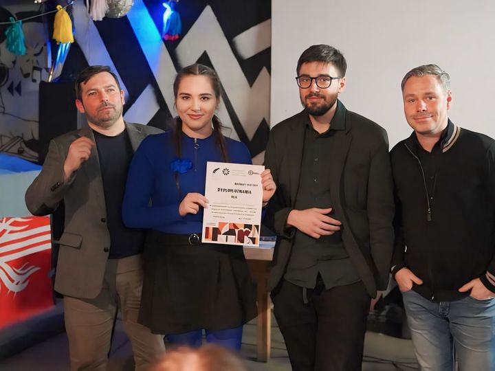 Anna Zborowska z dyplomem w dłoniach w towarzystwie trzech mężczyzn po wydarzeniu literackim w klubie